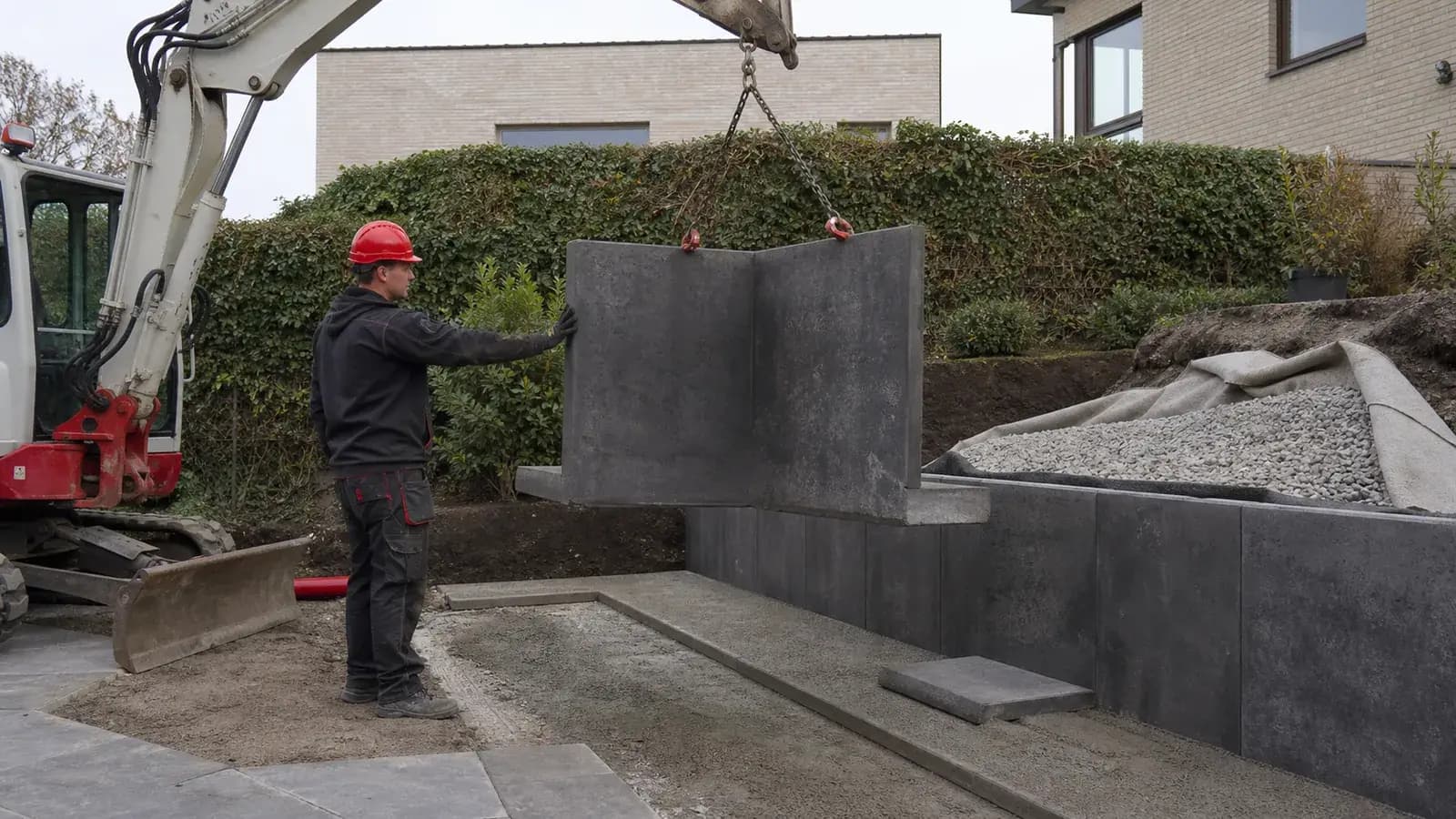 Antraciete keerwand in aanleg tussen twee niveaus van een moderne Nederlandse tuin