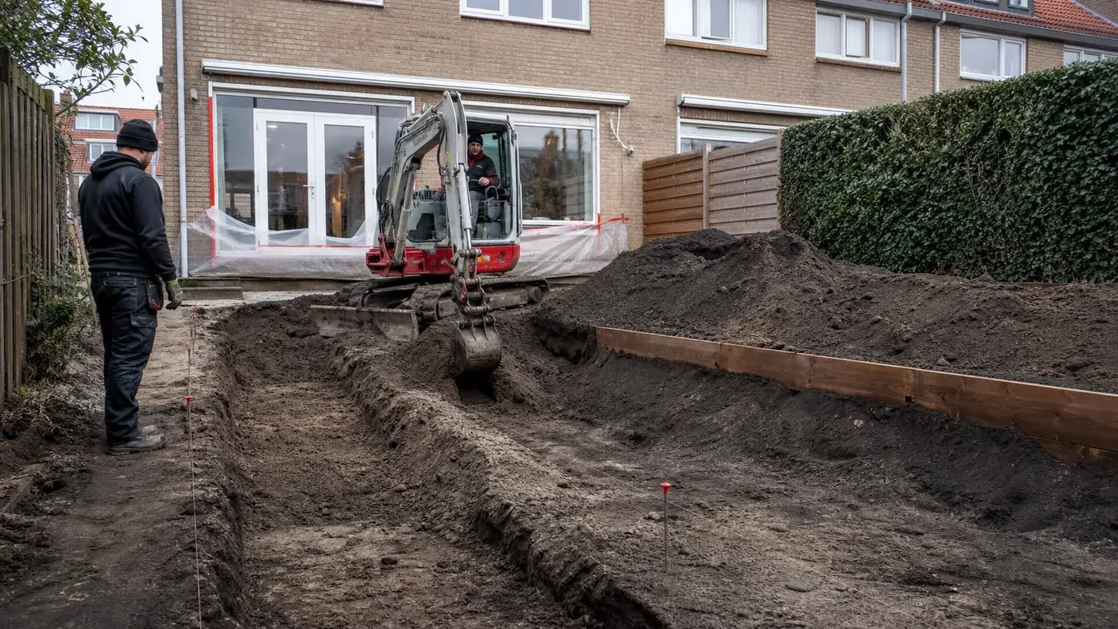 Minigraver brengt een Nederlandse achtertuin zorgvuldig op nieuw hoogtepeil