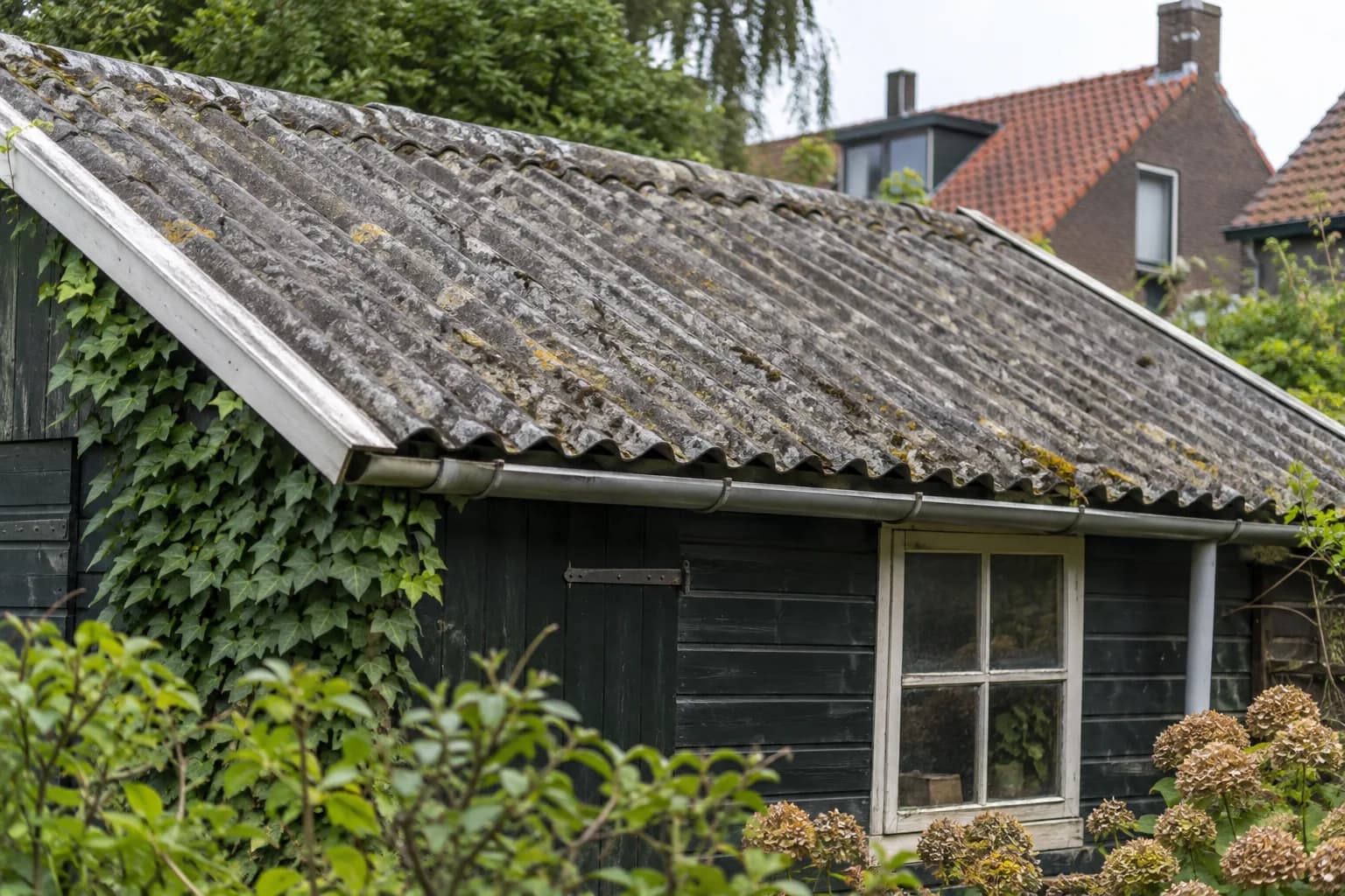 Verweerd golfplatendak van een oudere tuinberging