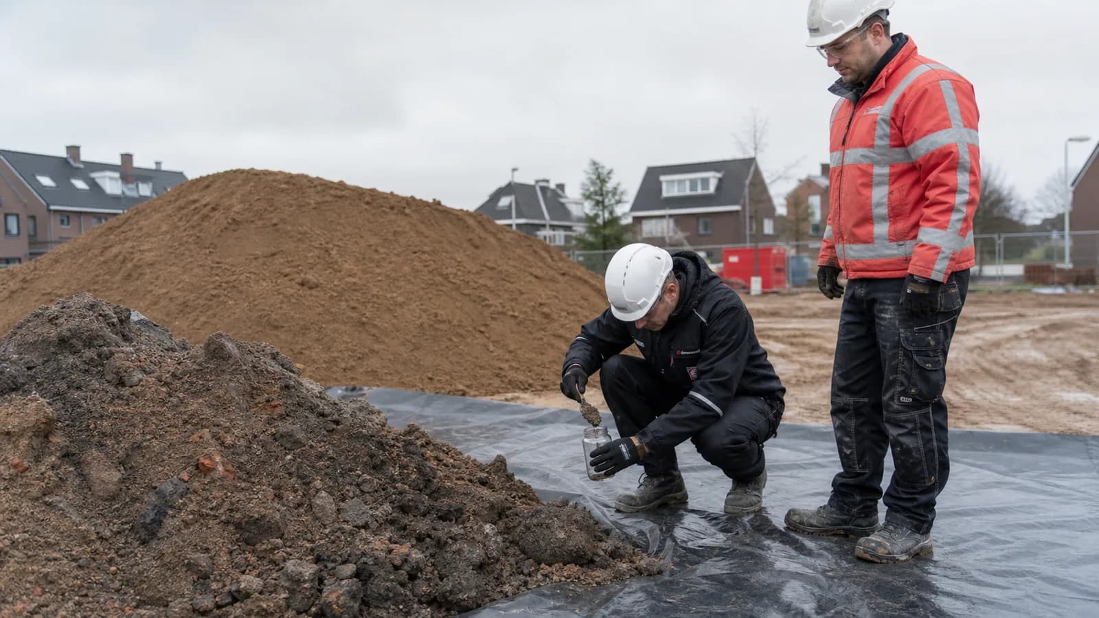 Gescheiden gronddepots met schoon zand en donkere bodem op een Nederlandse werklocatie
