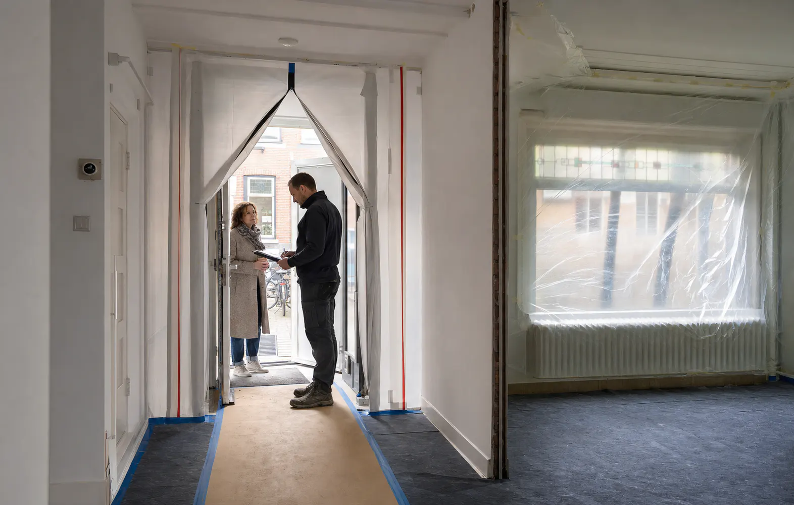Netjes voorbereide Nederlandse woning voor sloopwerk met stofschot en beschermde looproute