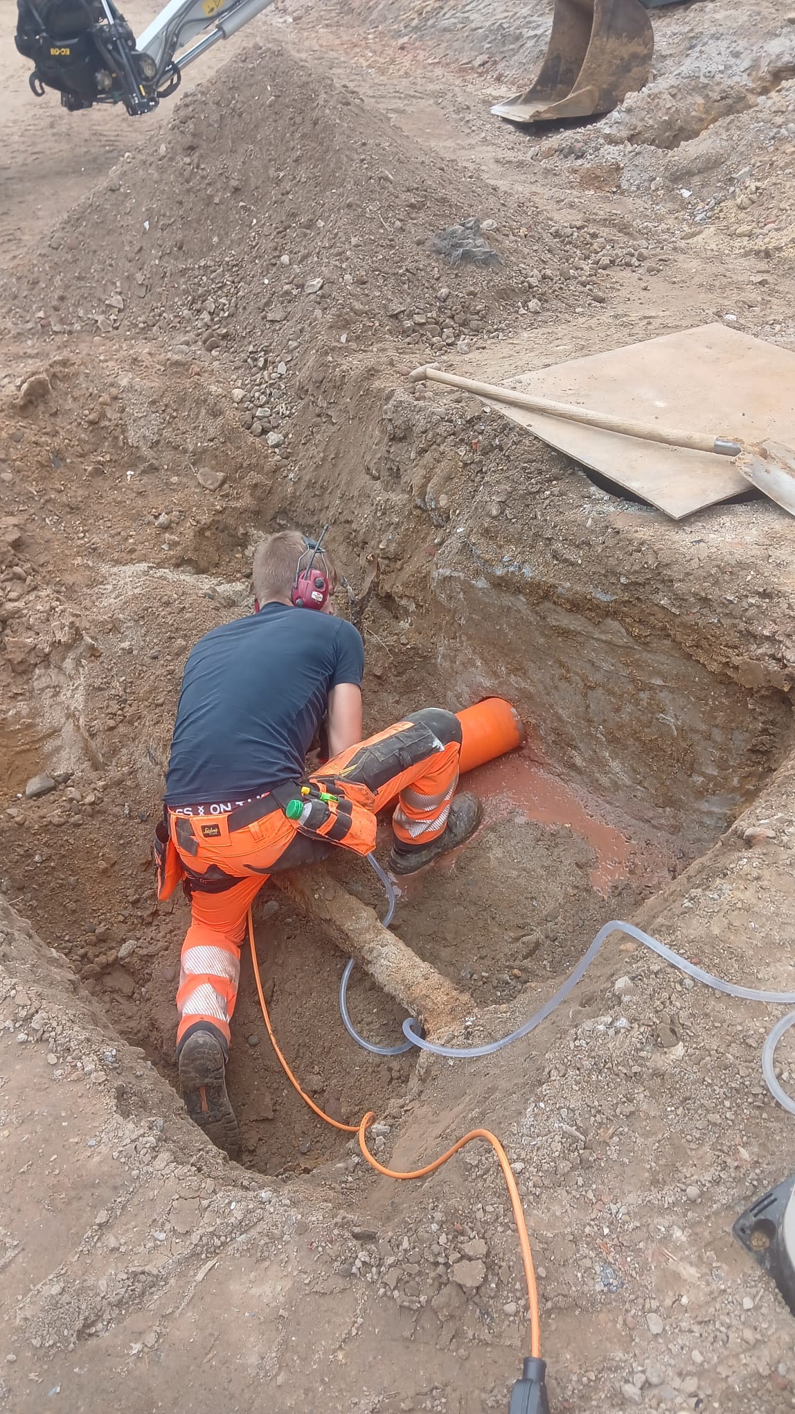 Dante Hoenjet voert een diamantboring in beton uit vanuit een uitgegraven sleuf