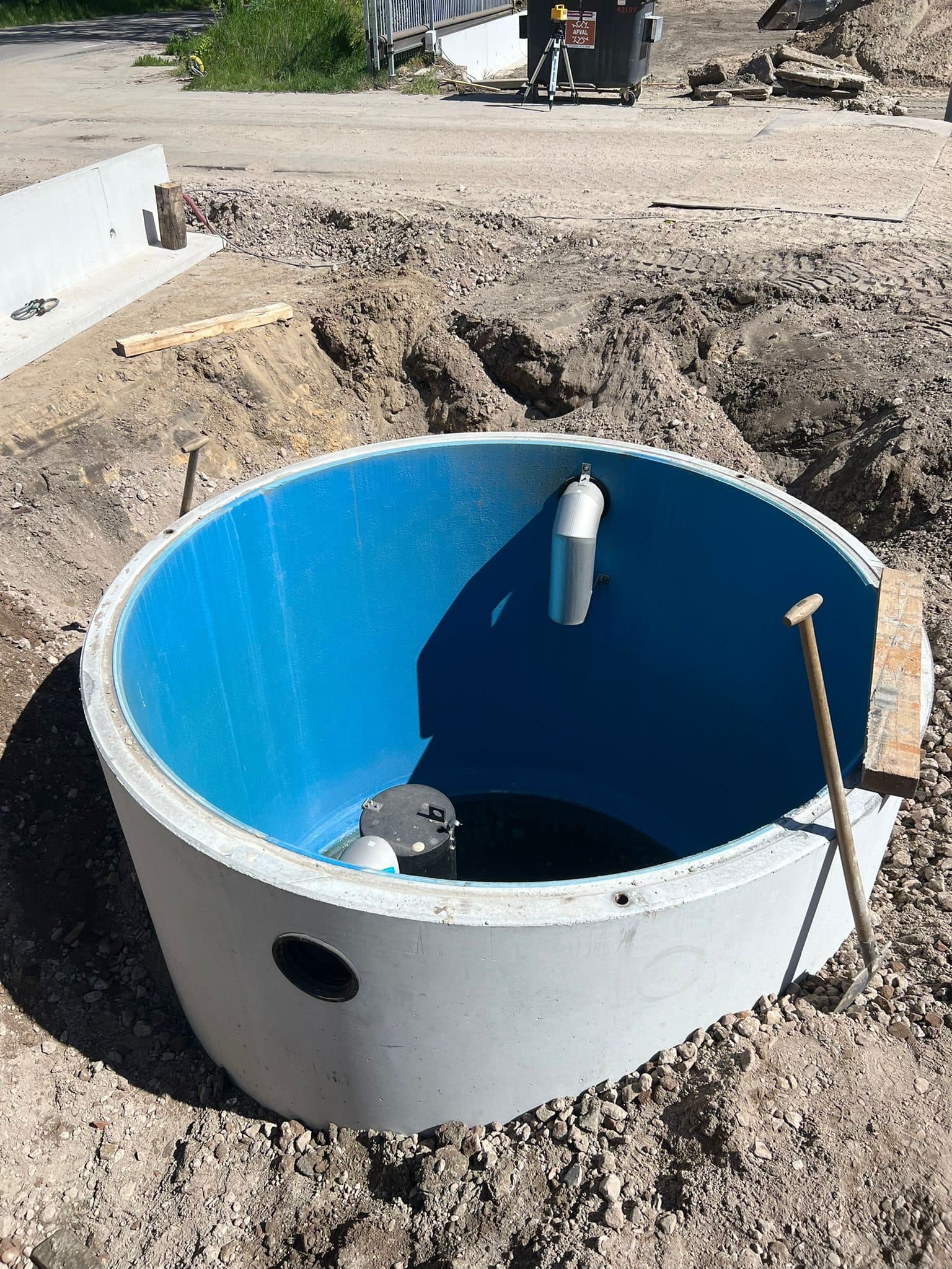 Olie- en slibafscheider: betonnen put met blauwe binnenzijde, ingegraven op een bedrijfsterrein